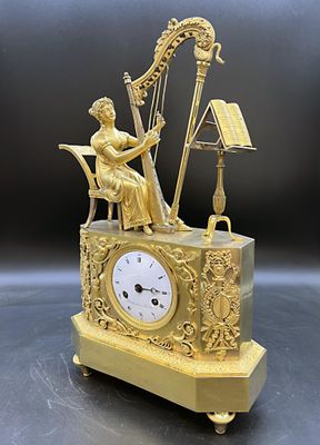 une horloge en or représentant une femme jouant de la harpe