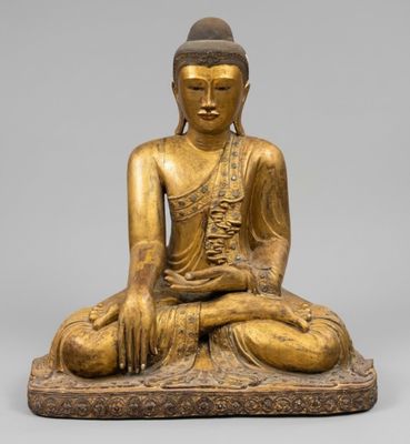 a gold statue of a seated buddha on a stone base