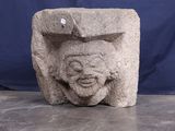une sculpture en pierre représentant un visage, posée sur une table