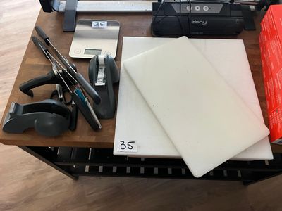une table sur laquelle se trouvent un ordinateur portable, des ciseaux et d'autres fournitures de bureau