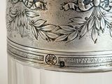 a glass jar with a silver lid sitting on a table