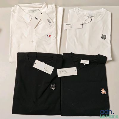 Il y a trois chemises blanches et une chemise noire sur une table
