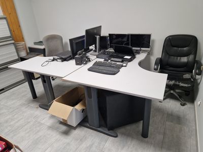 an image of a desk with two computers and a chair