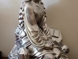 une statue en argent représentant une femme assise sur une table