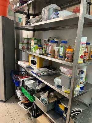 une cuisine équipée d'un réfrigérateur et d'étagères remplies de provisions
