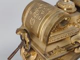 a gold clock with a bird on top of it