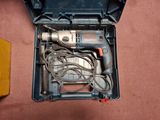 a drill in a tool box on the floor