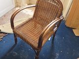 une chaise en osier dans un coin de la pièce