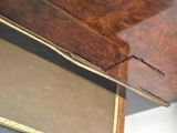 a wooden desk with a glass top and a gold trim