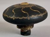 a black and gold mushroom shaped object on a white surface