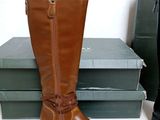 a pair of brown boots sitting on a stack of books