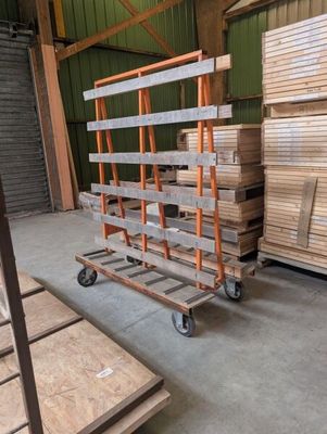 several pallets of wood are stacked on a dolly in a warehouse