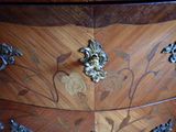 a wooden chest of drawers with ornate designs on it