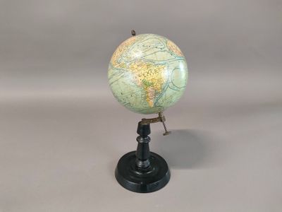 a small globe that is on a stand on a table
