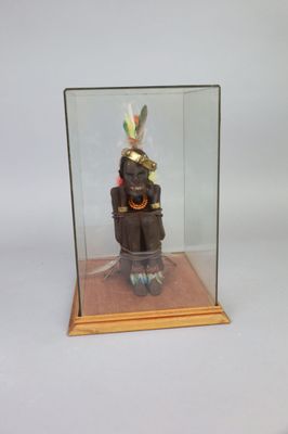 a glass display case with a figurine of an indian man