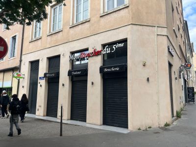 des personnes marchant sur le trottoir devant un immeuble