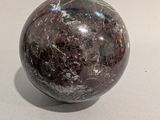 a marble ball sitting on a table with a shadow on it