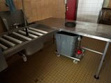 an image of a kitchen with a sink and a trash can