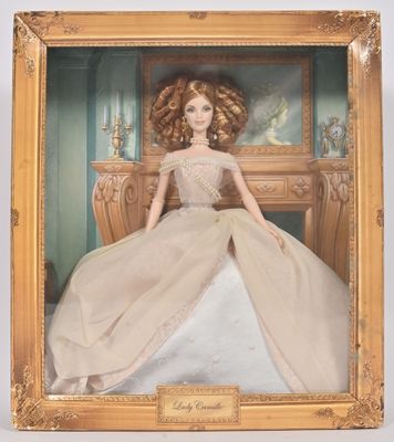 poupée Barbie dans un cadre doré, vêtue d'une robe blanche à bordures dorées
