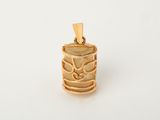a close up of a gold pendant on a white surface