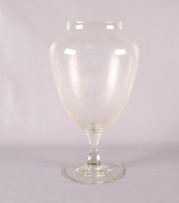 un vase en verre transparent posé sur une table blanche