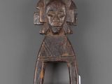 a wooden figure of a woman with a hat on her head