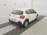 the small white car is parked in a clean room