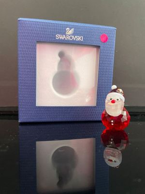 une photo d'une figurine du Père Noël devant un cadre photo