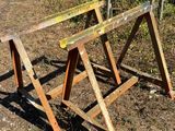 two wooden benches that are sitting in the dirt