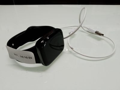 une Apple Watch noire et blanche posée sur une table blanche