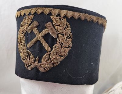 un chapeau noir orné d'un emblème doré