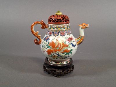 a small teapot with a lid on a stand
