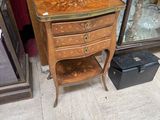 a small table with a drawer on it in front of a mirror