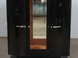 a black cabinet with a mirror on top of it