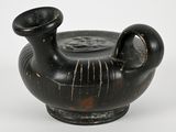 a black vase that is sitting on a white surface
