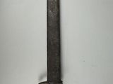 an old knife hanging on a wall in a room