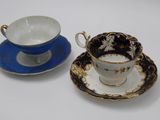 two cups and saucers sitting on a white table