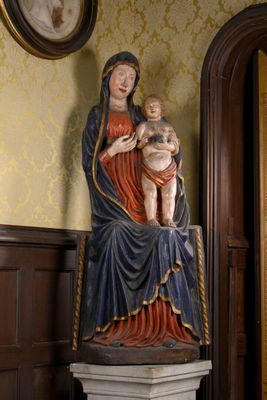 une statue représentant une femme tenant un bébé dans ses bras, posée sur un socle