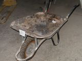 une brouette au milieu d'un garage, avec une échelle à côté