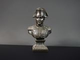 statue représentant le buste d'un homme portant un casque, posée sur une table noire