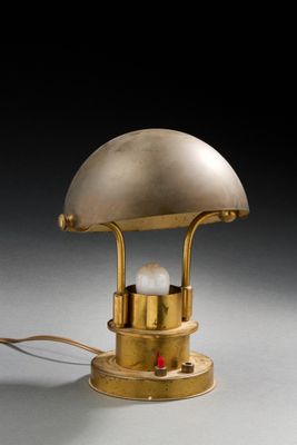 une image représentant une lampe de table dorée sur laquelle est posée une ampoule