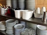 beaucoup d'assiettes et de bols sur les étagères de la cuisine