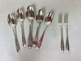 five spoons, two forks, and a knife on a table