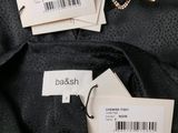 the label on the back of a black jacket with a barcode on it