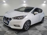 la voiture blanche est garée sur un sol en damier dans le garage