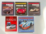 quatre livres posés sur une surface blanche, avec une Porsche 911 et une Porsche 911