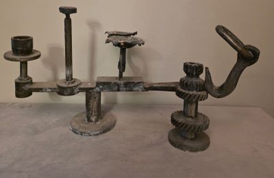 une sculpture en métal représentant un homme coiffé d'un chapeau, posée sur une table