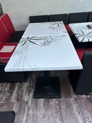 a white table with red cushions and a black and white bench