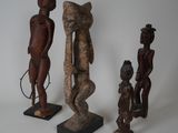 trois sculptures en bois de formes et de tailles différentes posées sur une surface blanche