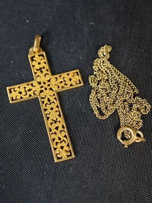 une croix en or et une chaîne en or sur fond noir